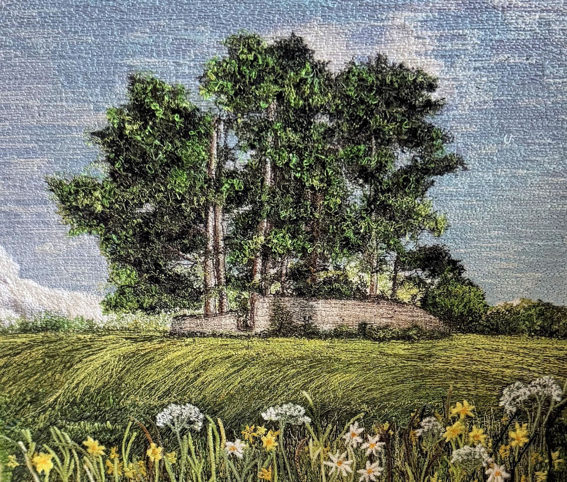 A stand of trees on a grassy rise, with white and yellow flowers in the foreground